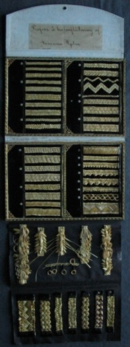 Provbok med halmflätning. "Profver å halmflätning af Susanna Hjelm".

I uppslaget på boken är proverna gjorda med skuren halm. Till flätproven är halmen 1mm bred eller 2mm bred. På vänster sida 19 prover och på höger16 prover.
Det finns ett fastmonterat tilläggsblad där man på vänster sida har 6 prover i skuren halm. På höger sida är det flätprov med hel halm, sju stycken.
På tilläggsbladet finns en beskrivning på halmens beredning.

Provboken är gjord av Märta Heydens mormor, Susanna Hjelm (Camitz), född 1858 i Stockholm. Hon gjorde den när hon var 10 år.