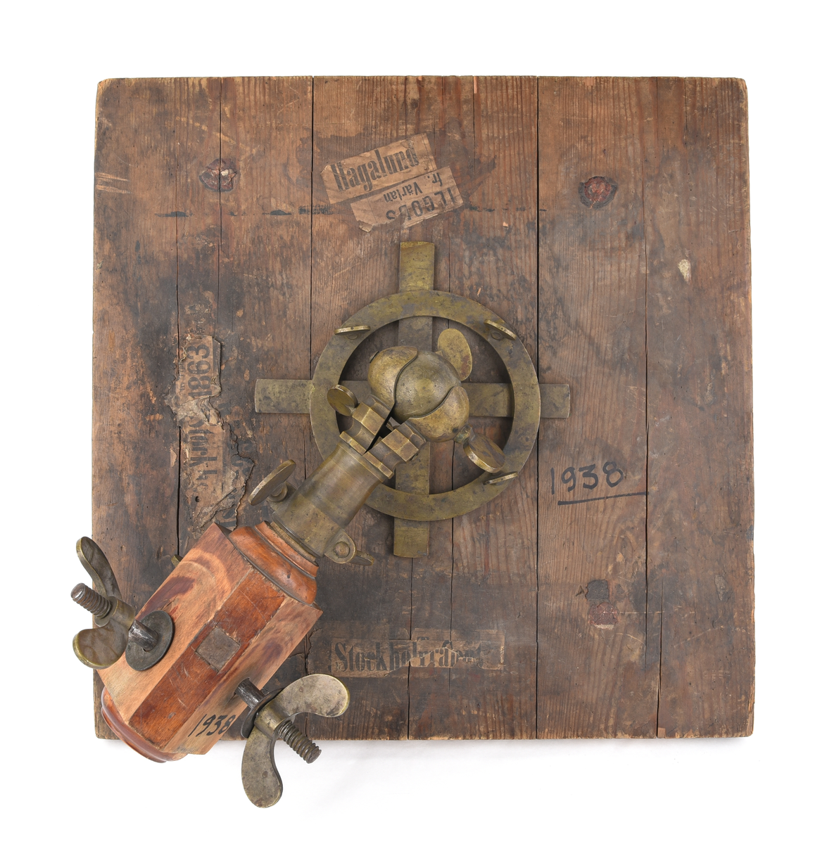 Ett mätbord på stativ med fodral.

Jvm01938-1: Mätbord bestående av en kvadratisk träskiva. Har använts för att spänna upp papper för att kunna göra ritningar. Framtill sitter två tejpbitar i vitt. Baktill finns fraktsedlar där det står bland annat i svart text "Hagalund, Ilgods fr. Värtan, Stockholm Central(?), 1863" på olika ställen. Finns även fyra svarta och röda sigillstämpelar där texten är svår att tyda. På baksidan sitter även stativhuvudet. Gjord av metall och trä och består av flertal skruvar. 

Jvm01938-2: Ett fodral gjord av vävd bomull med påmålad svart färg för att skydda mätbordet mot vatten. Sömmen i mitten av fodralet är sprucken och det har uppkommit hål där träskivan har skavt mot fodralet. Banden på fodralet har lossnat på vissa ställen men knutits ihop för att sitta fast på mätbordet.

Jvm01938-3: Stativ bestående av tre ben som fästs i stativhuvudet på mätbordet. Upptill ett hål på vardera ben. Nedtill spetsiga ben, klädda i metall. Kvadratiskt formad med rundade hörn.