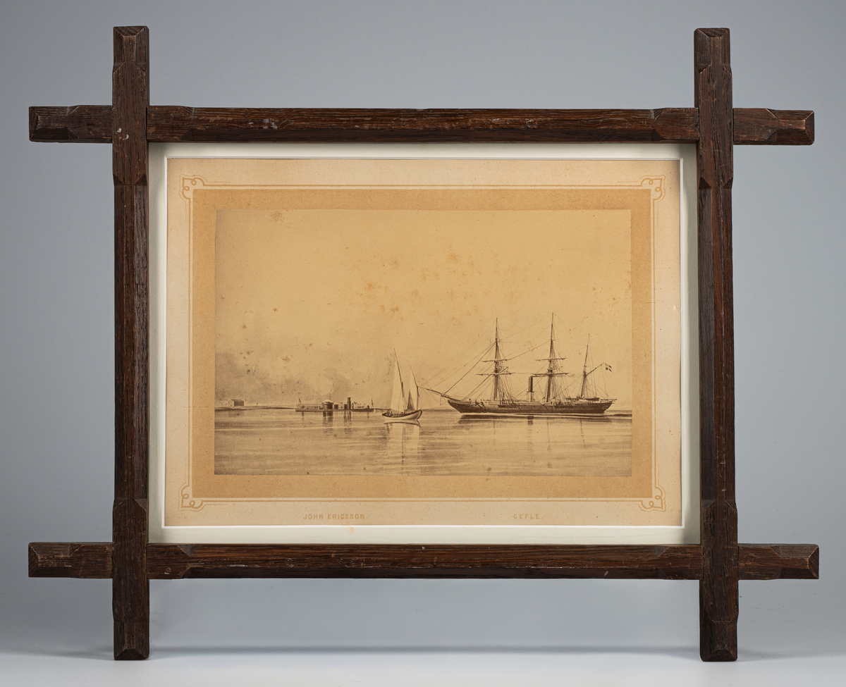Fotografi inom glas och ram. Ramen av trä med kryssade hörn och betsad.
Visar ångkorvetten Gefle och monitoren John Ericsson under gång för maskin i Karlskrona skärgård.
Märkt på kartongen: John Ericsson  Gefle.