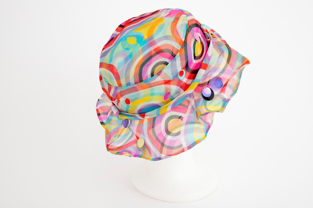 Liten chiffonhatt i solhattfasong med påtrykt mønster og påsydde paljetter.