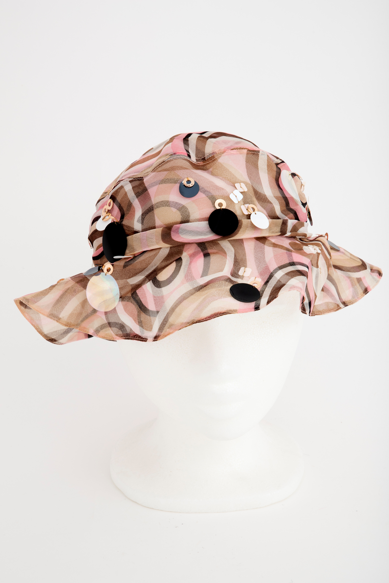 Liten silkechiffonhatt i solhattfasong, påtrykt mønster av svarte, brune, beige, hvite og rosa sirkler.