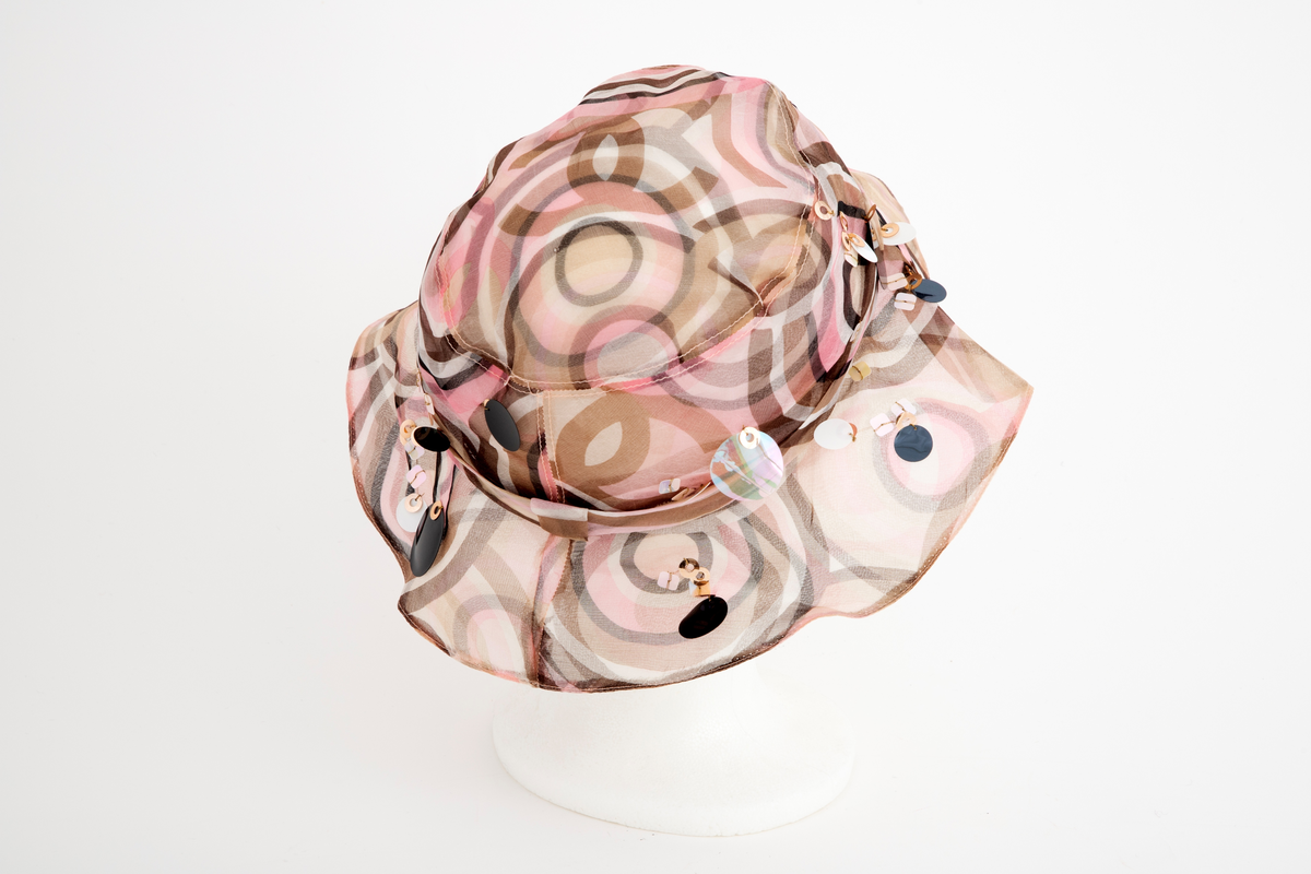 Liten silkechiffonhatt i solhattfasong, påtrykt mønster av svarte, brune, beige, hvite og rosa sirkler.