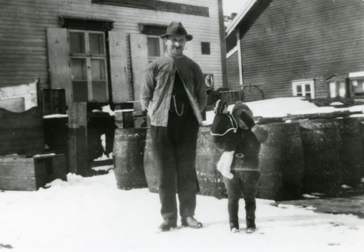 Gjesvær. En mann og en ung jente med en dukke står på kaia.