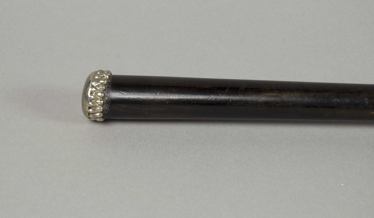 Dameparaply med sort silketrekk, metallspiler, trestang og på enden av håndtaket en liten metallholk.