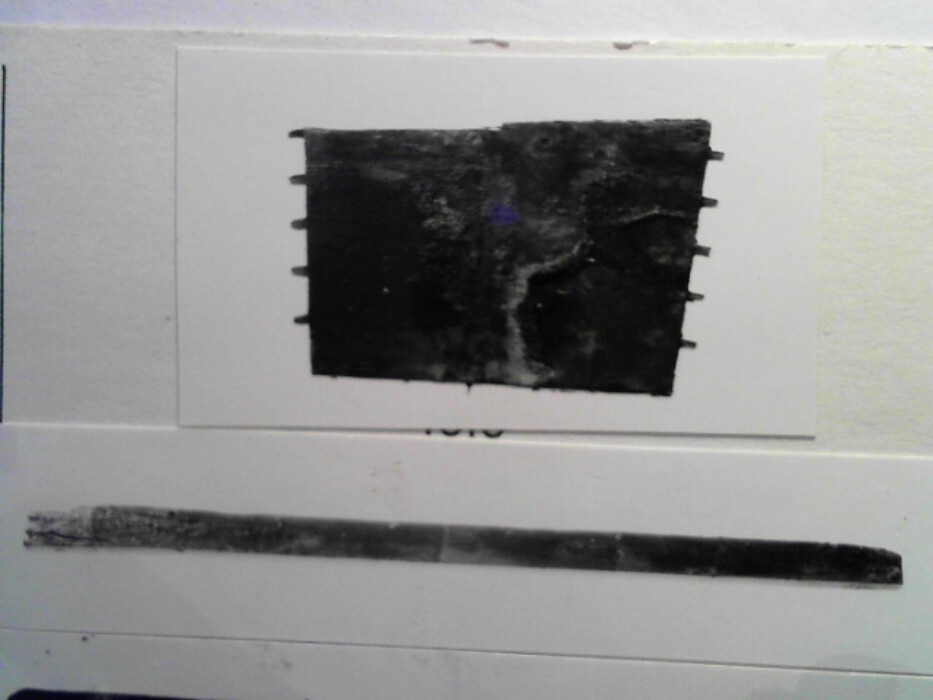 Furu. Gran ?. Kistens langsider er skråttstillet slik at kisten er smalere nede enn oppe. Bunnen består av to bord ; et bredt bord lengde 84 bredde 34 tykkelse 3,2 (bordet er nå brukket) og et smalt bord bredde 4,5. Trenagler med diameter 0,6 er slått fra undersiden opp i kistens sidebord. 6 stykker på kortsidene og 8 stykker på langsidene. Hver av kortsidene har opprinnelig vært i ett bord tykkelse 1,7. I sidene er tapper for sinking. De har trekantet tverrsnitt med innerside 0,9. Avstanden mellom tappene er 3,6. Langs ytterkantene er en ekstra kant 0,3 x 0,3 som svarer til et spor i langsidene. Dette for å styrke sinkingen. I øvre delen av hver kortside 2 hull med diameter 0,7 og 5,9 fra hverandre. Disse er for håndtak og det er antydninger av at et halvsirkelformet beslag har vært rundt dem. Et jernbeslag bredde ca 3,4 har gått fra dette nedover bøyet om kanten og 2,2 inn under bunnen. :: I hjørnene har det også vært beslag. Det er mulig at spor under hanken antyder at det har vært  en taustropp som har hengt i bue. Baksiden består av 2 bord tykkelse 1,7 og henholdsvis bredde 16,8 og bredde 7,8. Forsiden består av ett bord tykkelse 1,7 og bredde 23,5. Der har antagelig vært et skjoldformet jernbeslag på forsiden. På baksiden er halvsirkelformet utsparing for låsen. 2 jernbånd ca 3,5 brede har ca 17 fra kortsidene gått rundt hele kisten og antagelig vært feste for lokkbeslaget. I venstre siden av kisten er en leddik av 1,2 tykke bord. Bunnbordet bredde 7,6 med en utstikkende skråkant under sidebordet som er høyde 6,5. Det er spor for leddiken i siden av kistebordene. I nederkant av leddikens sidebord en trapesformet innfelling.