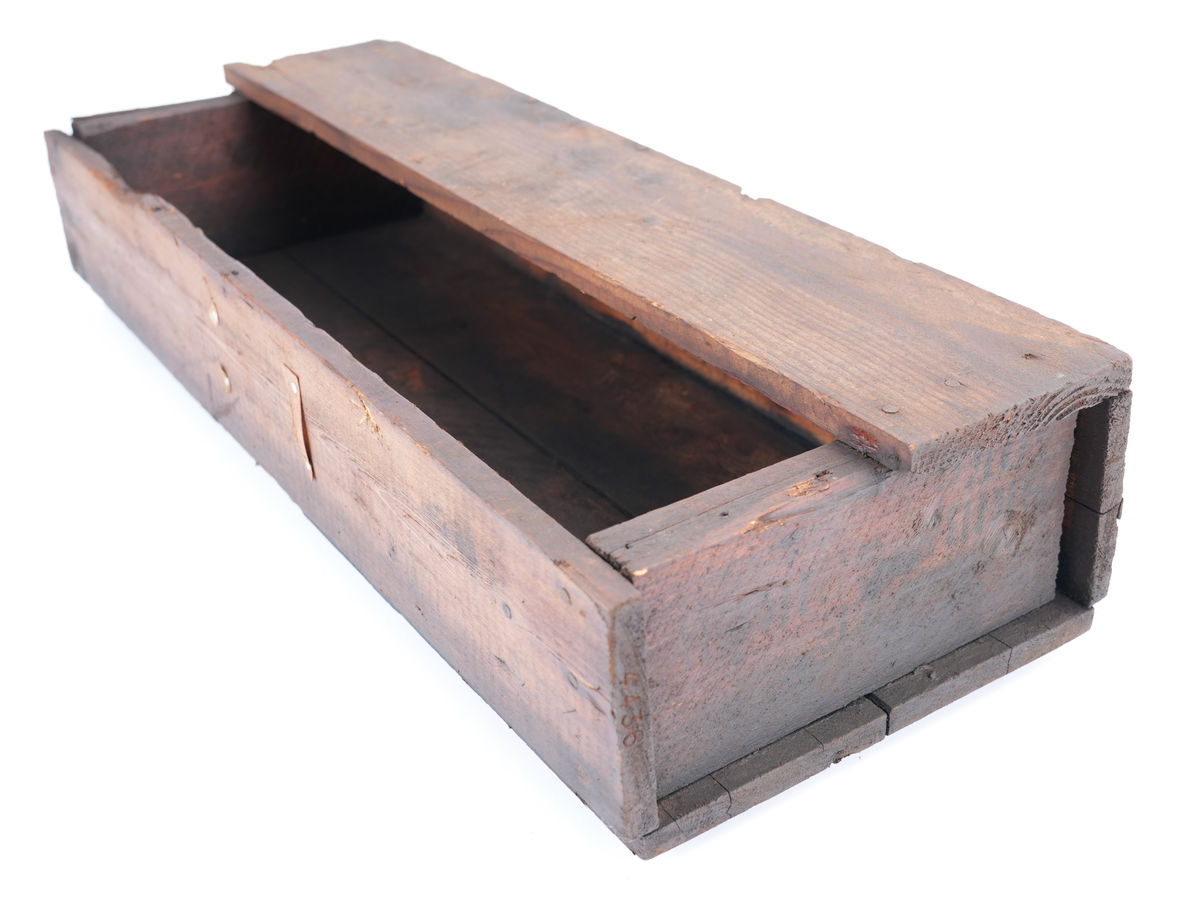 Trekasse fylt med 284 store spikar. På kassa er det trykt tekst. Oppsida av kassa er halvt ope, slik at øvre halvdelen av spikrane er synlege. Spikrane er like: Hovudet meir ovalt enn rundt, og litt kantete. Sjølve spikaren har fire sider og smalnar inn nedst. To av sidane er breiare enn dei to andre.