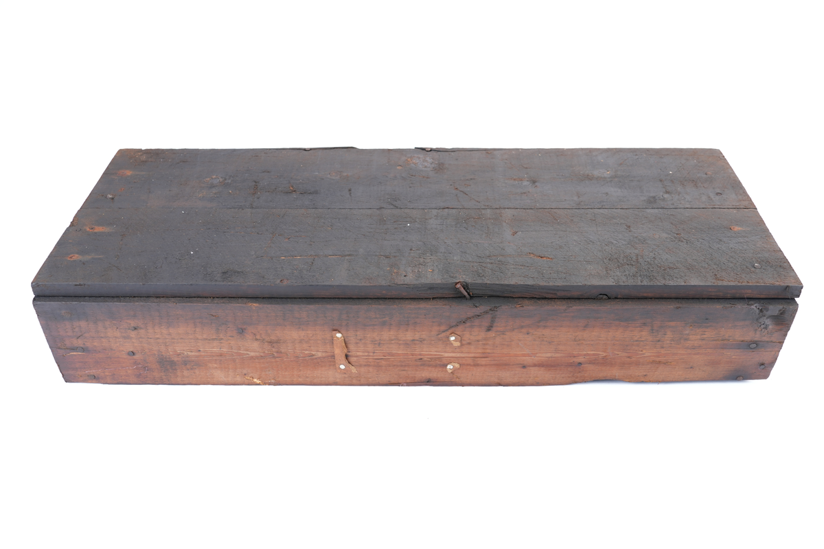 Trekasse fylt med 284 store spikar. På kassa er det trykt tekst. Oppsida av kassa er halvt ope, slik at øvre halvdelen av spikrane er synlege. Spikrane er like: Hovudet meir ovalt enn rundt, og litt kantete. Sjølve spikaren har fire sider og smalnar inn nedst. To av sidane er breiare enn dei to andre.