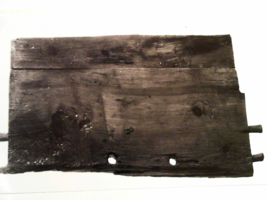 Gran. Kistens langsider er skråttstillet slik at kisten er smalere ned enn oppe. Bunnen består av 2 planker tykkelse 2,2. Fra bunnen er slått spiker med store hoder opp i kistens sidebord. Spikernes hoder er diameter 1,5 og deres side er 0,6 x 0,4. Kortsidene er trapesformete hver av dem laget av 2 bord tykkelse 1,75. I sidene på dem er dels tappet inn trenagler dels slått inn spiker fra langsidenes ender. Vel 20 fra bunnen er i hvert endestykke 2 hull med diameter 1 og 7 fra hverandre. Disse er for hankene. I ett av hullene satt det igjen rester av tau som var slått av 3 kordeler. Det smale bordet nederst i forkant er bredde 8,4 og tykkelse 3 nederst. oppe er det tykkelse 2,6. Det smale bordet nederst på baksiden er 8,3 i ene enden og smalner til 6,9. Det er 2,6 tykt nederst og 2,1 tykt oppe. De øvre brede bordene er tykkelse 2,3 og henholdsvis bredde 10,7 og 9,5. Det smale bordet i forkant har på oversiden 3 spor etter tretapper diameter 1 i overkant men ettersom det ikke er tilsvarende hull i nederkant av det ovenforstående brede bord tyder dette på at kisten er reparert med et nytt bord i nedre forkant. Dette kan forklare hakkene i sidene av endestykkene. I de lange bordene er det i hjørnet en dyp utsparing for de tilstøtende kortsider. I hjørnene er tappene slått inn fra langsidene. De syns å ha vært tretapper men av vekslende dimensjoner. På de brede øvre plankene er i midten tre tapper på hver side med diameter 1 og lengde 8. På hver side av dem er en mindre nagle diameter 0,6. I de nedre smale fjelene har trenaglene delvis vært erstattet med spiker med store hoder. :: Kisten har hatt lokk festet til 2 brede jernbånd som har gått ned på baksiden ca 11,5 fra yttersiden. Kisten har i forsiden nøkkelhull og spor etter beslag om dette festet med 2 spiker. På innersiden utsparing for selve låsen som har vært dekket av et beslag med buet profil.