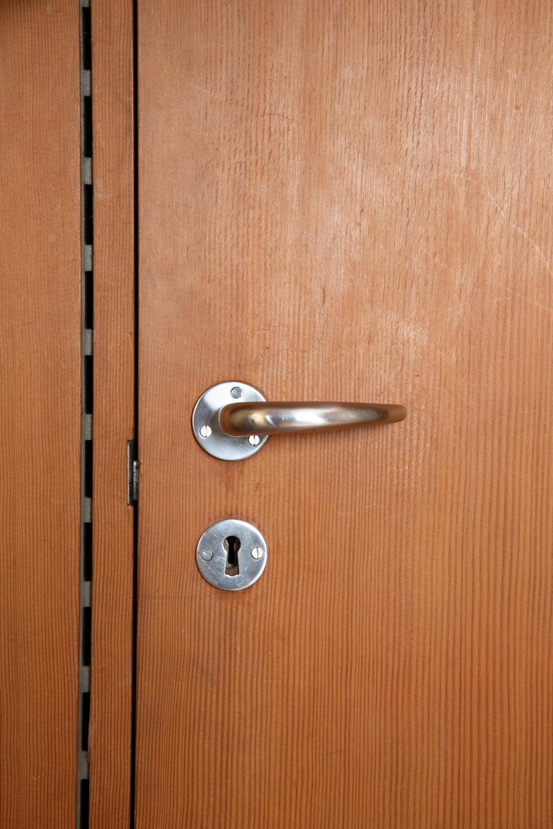 Panelvegg med flyttbare hylleseksjoner. Blant seksjonene finnes to diskmontre i mørkebrun rio-palisander med glass i lokket. Toppflatene skrån fremover, og lokkene er låsbare. Festet til bakvegg. Det er fire åpne reoler i dansk løn. Disse er to-det i bredden med lave skillevegger med buet profil. Det er fire lukkede veggmontre i dansk lønn. Glass på forsiden. Rektangulær kasseform. I tre av skapene er bakveggen malt lys blå, i den fjerde er bakveggen rødbrun. Bakveggen og dend rør er i douglas-gran