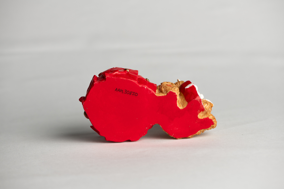 Bamse med sløyfe og hjerte rundt halsen, sittende, holder et hjerte med sløyfe i fanget. Ved siden av ligger mange uåpnede brev forseglet med hjerter, disse danner rundt fundament for det løse telysglasset.