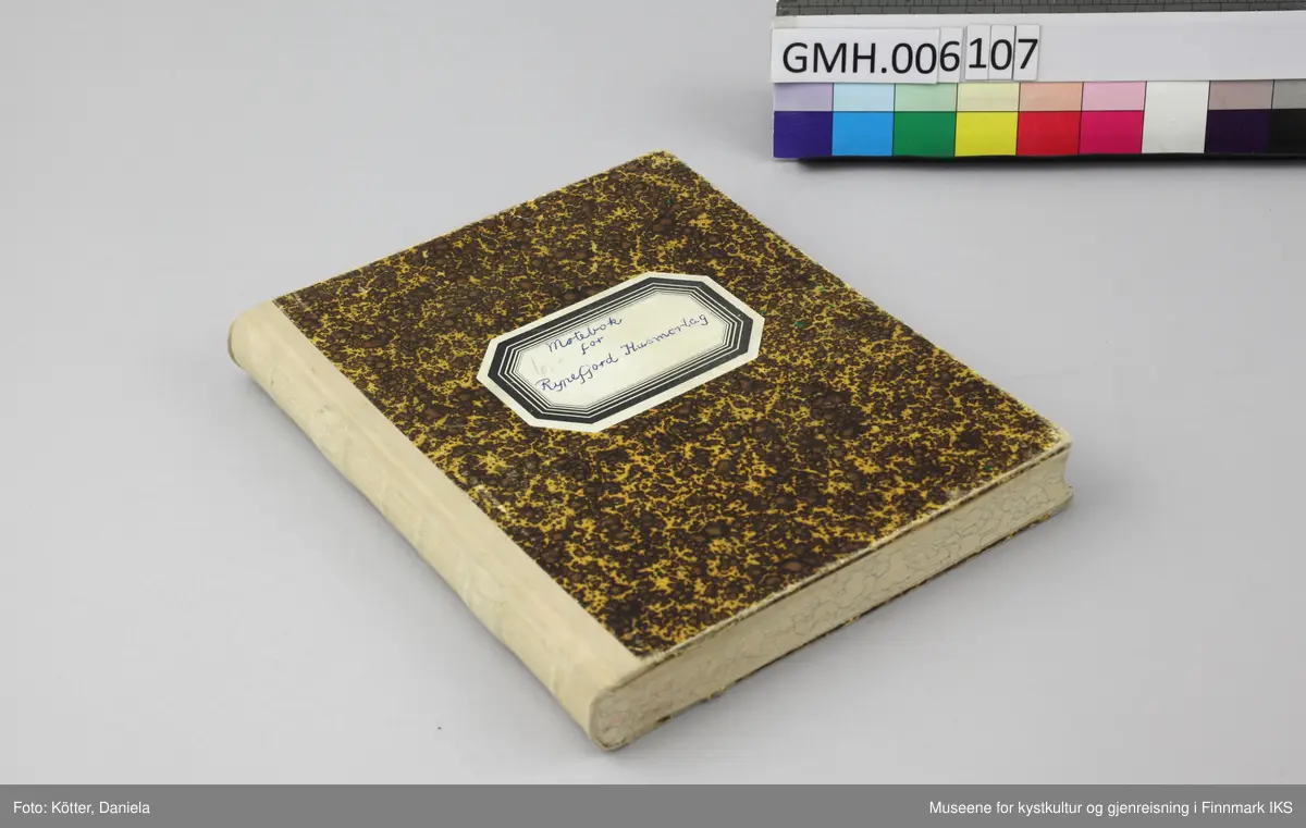 Møteboka for Rypefjord Husmorlag er et linjert notatbok med solid pappomslag med gulbrunt mønster. På forsiden er det påført en åttekantet etikett. Boka har en beige, tekstilforsterket rygg og er velholdt og i god stand.