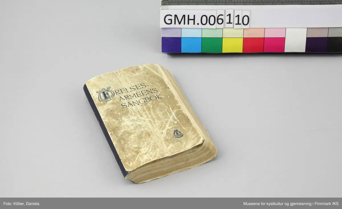 Liten, noe tykkere sangbok med omslag av tynn papp. Påtrykket på omslagets forside er blått.  Lyre-symbol i tittelen og Frelsesarmeens "Blod og ild"-logo nederst til høyre. Ryggen beskyttet med mørkeblå tekstil. En del bruksspor og misfarginger på omslaget. Øverst på forsiden er det en påskrift med blyant som har blitt nærmest uleselig, "Brita Eide".