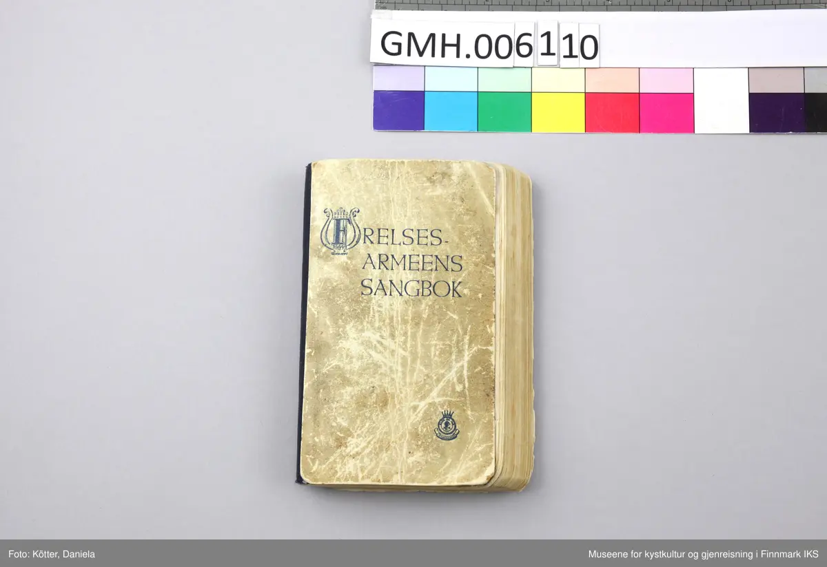Liten, noe tykkere sangbok med omslag av tynn papp. Påtrykket på omslagets forside er blått.  Lyre-symbol i tittelen og Frelsesarmeens "Blod og ild"-logo nederst til høyre. Ryggen beskyttet med mørkeblå tekstil. En del bruksspor og misfarginger på omslaget. Øverst på forsiden er det en påskrift med blyant som har blitt nærmest uleselig, "Brita Eide".