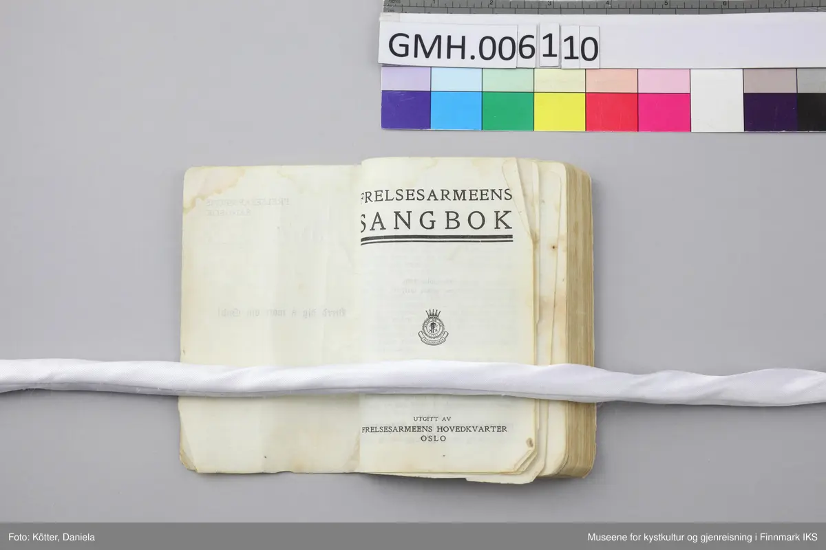 Liten, noe tykkere sangbok med omslag av tynn papp. Påtrykket på omslagets forside er blått.  Lyre-symbol i tittelen og Frelsesarmeens "Blod og ild"-logo nederst til høyre. Ryggen beskyttet med mørkeblå tekstil. En del bruksspor og misfarginger på omslaget. Øverst på forsiden er det en påskrift med blyant som har blitt nærmest uleselig, "Brita Eide".