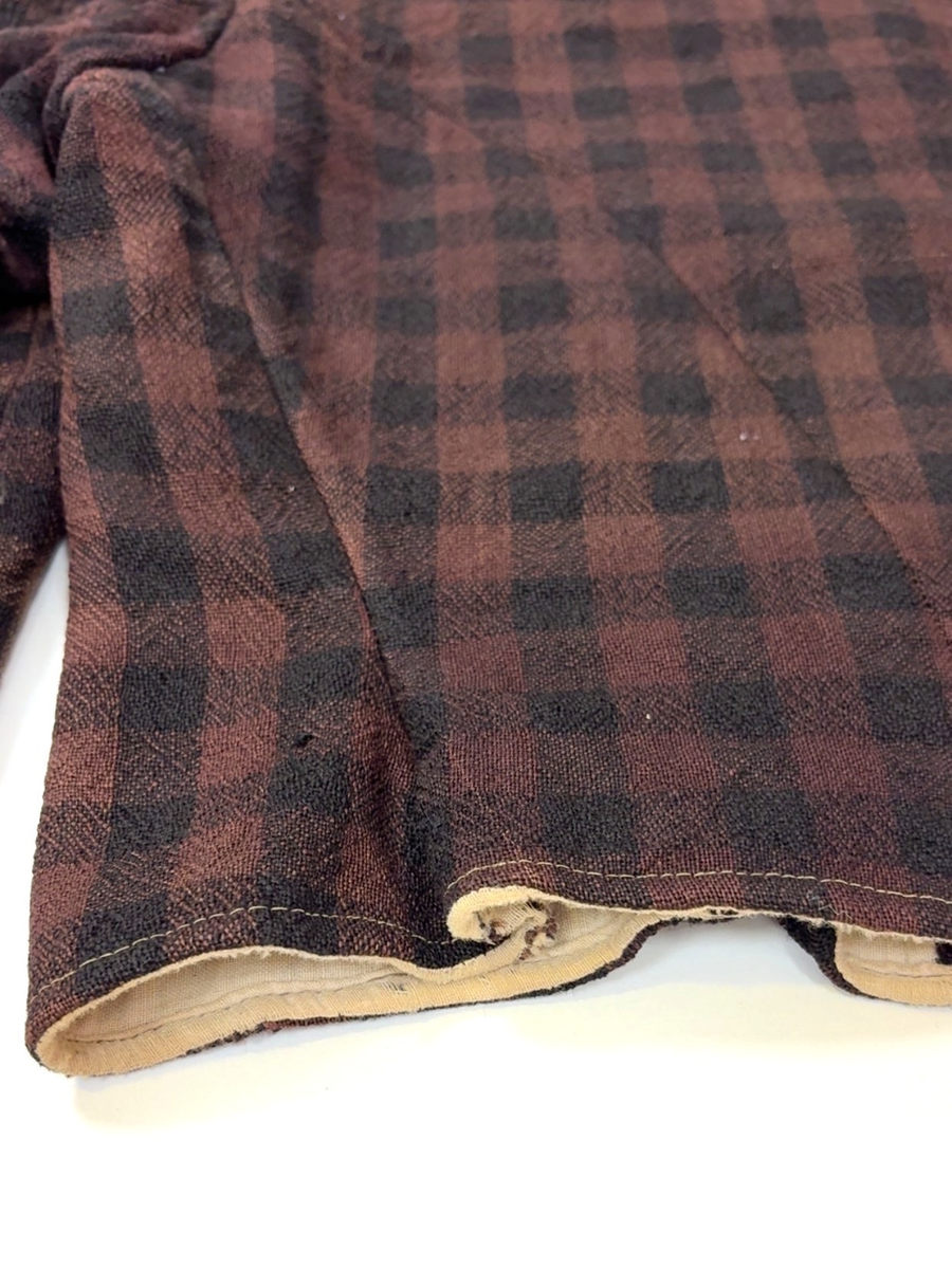 Kjoleliv i svart og brunrutet ull i hjemmevevd toskaft med ermer og bol i samme stoff. Livet er i dag velbrukt, falmet og slitt, med hull på albuene. Sydd for maskin og hånd med panelsøm og bakovertrekte skuldersømmer og sidesømmer. Rund rigning i halsen og buet fremkant. 1,5 cm bred halslinning sydd med maskin og lagt over og festet med faldesting og prikkesting i svart bomullstråd. Tett lukket med 13 par metallhekter med en 1,5 cm bred stolpe som skjuler hektingen. Kantene fremme er først sydd med maskin med brun sytråd og med leggsøm med brun bomullstråd. Livet har et innsnitt som er 3 cm på det bredeste under bysten, sydd med maskin. Smal tosøms krokarm. Livet er helfôret med ubleket bomull i hjemmevevd toskaft og sydd på samtidig som ullstoffet ble sydd sammen med maskin og spilesøm med tykk bomullstråd for hånd. Livet brukes ned i stakken og har hatt en metallkrok midt på bak til å hekte stakken på.