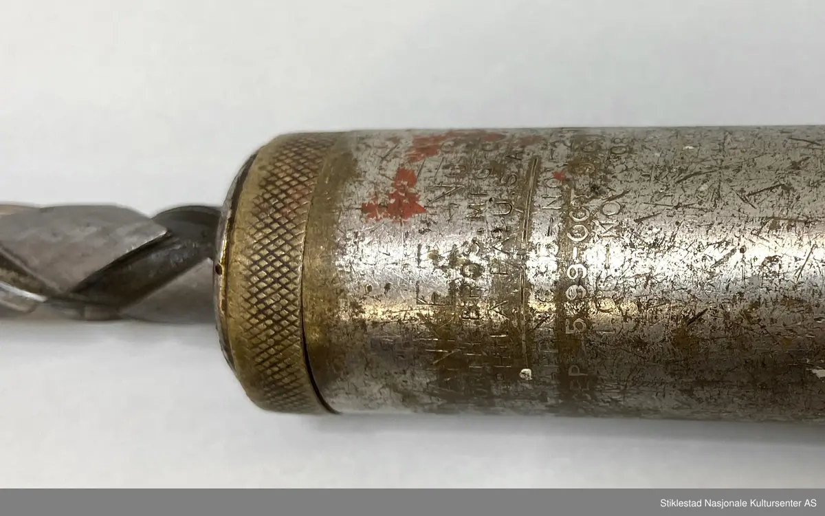 Skrujern med skrallefunksjon, flatskrujern. Skaft i løvtre, resten i metall/blikk. Utskiftbart skrujern, pumpefunksjon. Innskrift/stempel vanskelig å lese, men amerikansk. Skaft svimerket med T. Øgstad, Stiklestad, Verdal (rundt stempel)