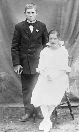 Portrett av en ung kvinne, sittende ved siden av en ung mann, stående.