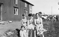 Portrett av fire jenter, et trekkspill og en sykkel.