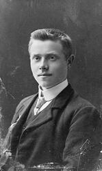 Portrett av en ung mann i mørk dress og vest, og hvit skjort