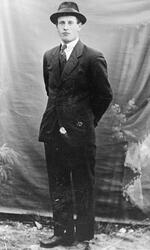 Portrett av en mann i dress, slips og hatt.