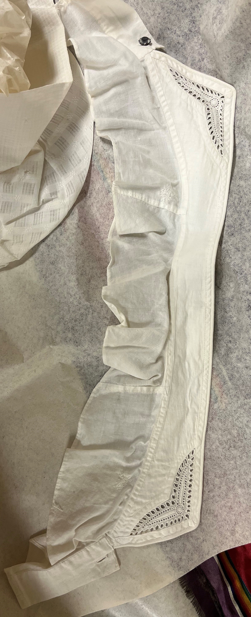 Sognebunad med følgande deler:
Belte - sölvkjede - silketörkle - tröye - silkeforkle - konehue - stakk - brosje - spenne/sölje - veske med lås.