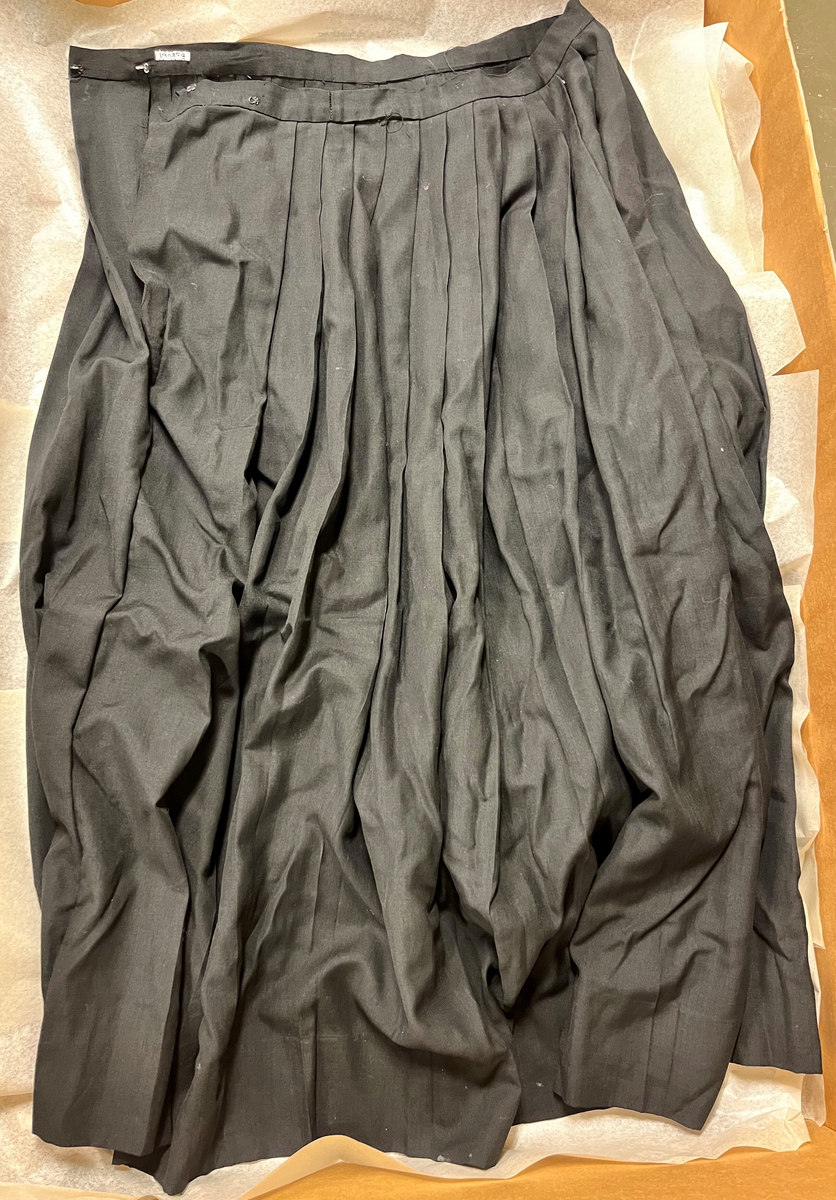 Sognebunad med følgande deler:
Belte - sölvkjede - silketörkle - tröye - silkeforkle - konehue - stakk - brosje - spenne/sölje - veske med lås.