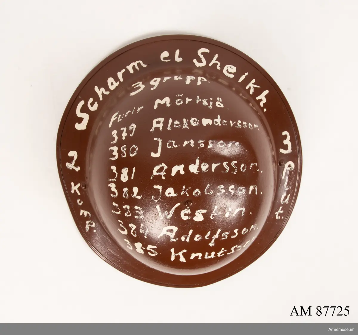 På hjälmens ovansida ditmålat med vit text: "Sharm el Sheikh 2 komp. 3 plut. 3 grupp
Furir Mörtsjö, 379 Alexandersson, 380 Jansson, 381 Andersson, 382 Jakobsson, 383 Westin, 384 Adolfsson, 385 Knutsson."

På insidan av hjälmen saknas hakrem och lös kedja ditsatt med okänd proveniens.

Insidan märkt längs kanten med otydlig prägling: 
P16 1
BM 1942
Möjlig brittisk tillverkare: BMB = Briggs Motor Bodies Ltd of Dagenham 1939 - 1945.