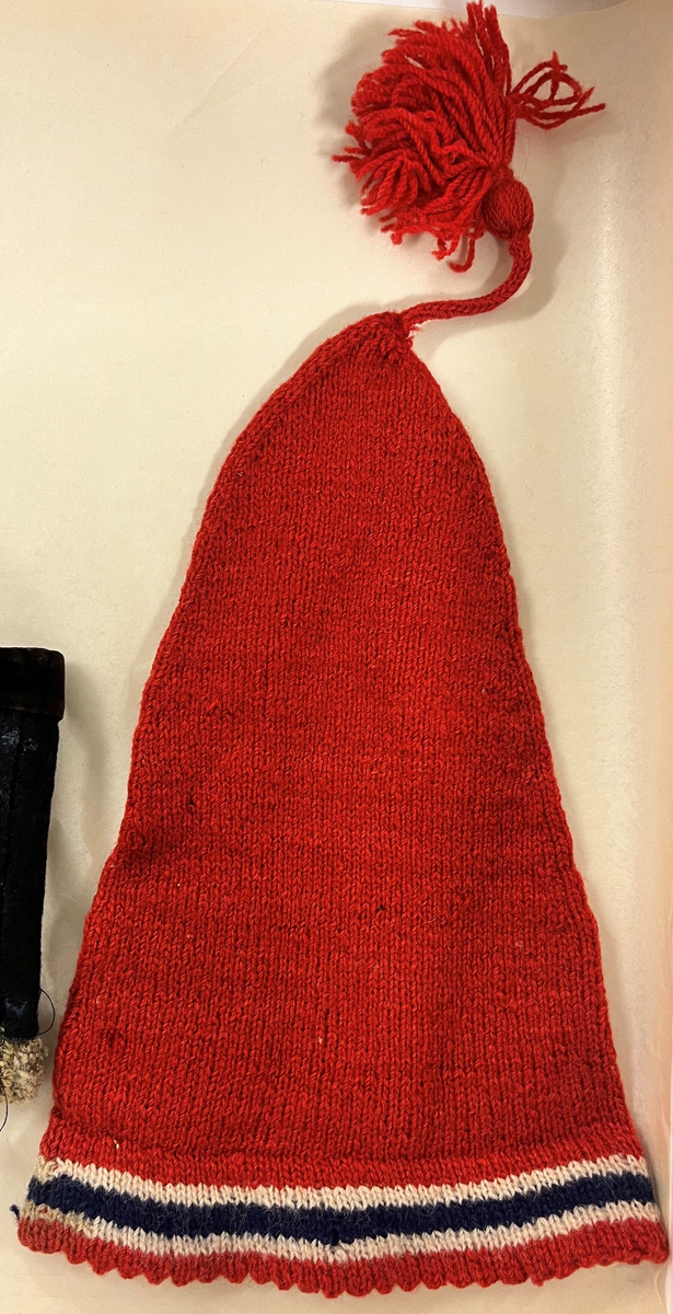 Rundstrikka, felt i spiss. Dobbel kant.
Rundstrikka snellesnor m/ dusk. P.g.a. forbod mot nasjonalfarger var slike huer populære under siste krig 1940 - 45