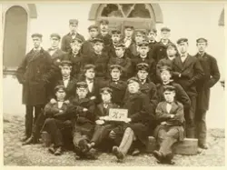 En läroverksklass har samlats utanför entrén till dåv. Växjö