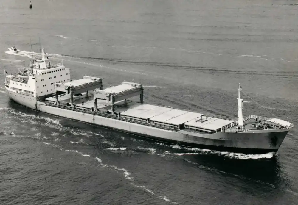 Viser et sort-hvitt bilde av et stort, moderne lasteskip, med et tomt container dekk.