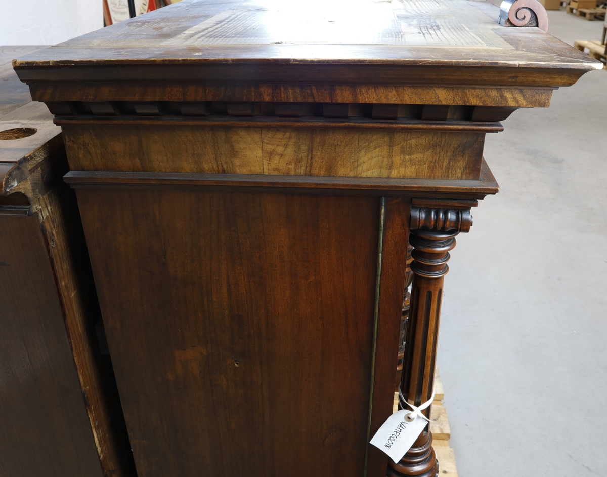 Vertikalstående, stor spilledåse av typen Polyphon, modell 54. Prod. nr. 3454. Maskinen bruker 63 cms plater.

Høyt skap i polert nøttetre med glassdør øverst og skuff nederst. Bak glassdøren ligger maskineriet og platearmen. Ved maskineriet ligger en lapp med bruksanvisning på tysk, engelsk og fransk. På skapetdøren, på hver side av glassplaten, står to rikt utskjærte dørsøyler. Øverst i hjørnene er det gjennombrudt akantus-utskjæringer. På høyre side av skapet er et myntinnkast som tar 5-øringer. Skuffen har to rikt utskjærte stolper og ornamentert metallhåndtak. Den åpnes på skrå og har plass til en rekke plater. Øverst i høyre hjørnet inne i skuffen er en mindre pengeskuff.

Til spilleren hører to små nøkler.