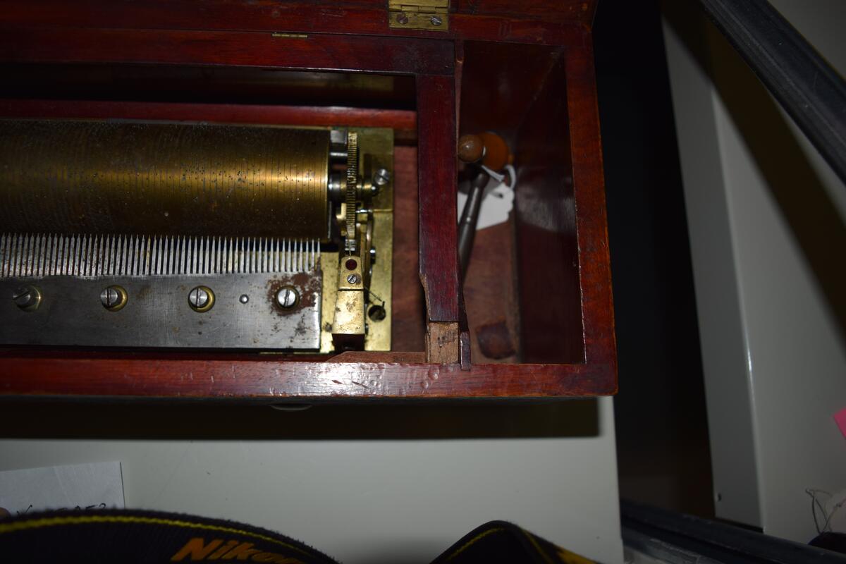 Nøkkeltrukket musikkmaskin med 12 melodier på en messingsylinder. Maskinplaten er av messing med en kam med 125 tenner. På venstre side er tre regulatorspaker. 

Kassen er lausert mørk brun på utsiden. På innsiden er den "okseblodrød" ,ed glasslokk og en skillevegg. På undersiden av lokket er det festet et melodikort. Nøkkelen ligger i en ekse i et avskilt rom på høyre side.