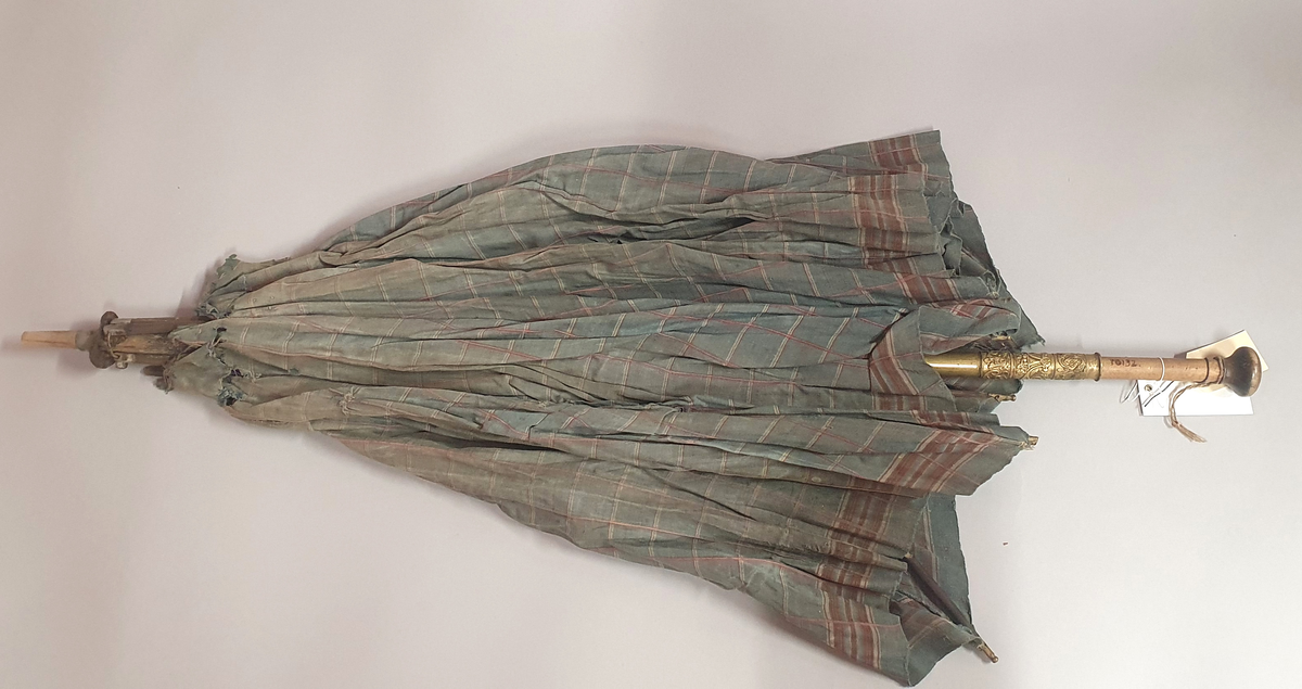 Paraply med rutete trekk av bomull og spiler av metall. Dekorert låsemekanisme av messing på skaftet.