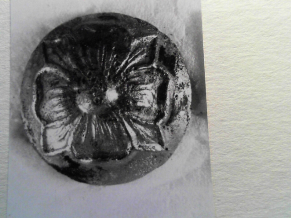 tinn ?. rund. hvelvet overflate. dekorert med 4-bladrose. støpt. hempen borte. høyde med hempe 0,7.