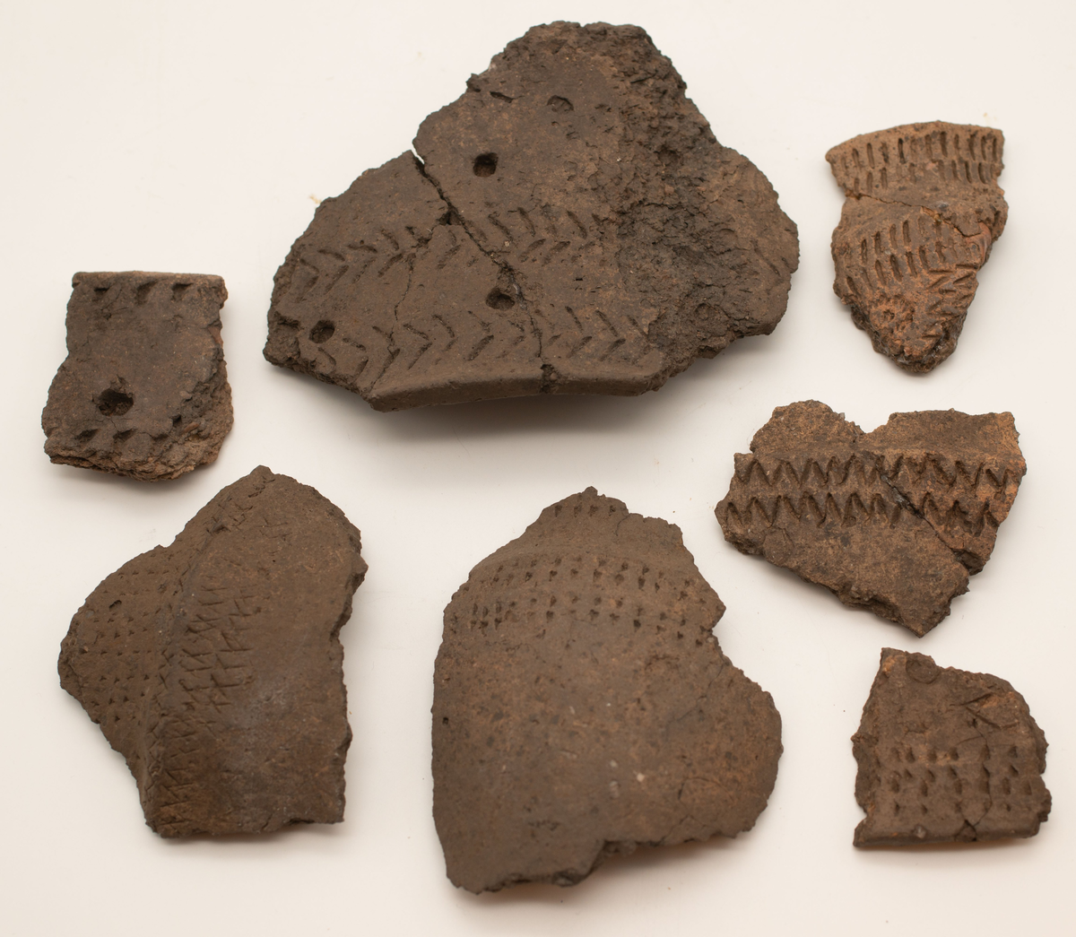 En större mängd (uppskattninsgvis ca 1000 stycken) ytplockade keramikskärvor. Skärvorna har i de flesta fall dekor. Dekoren består av streck, zig-zag mönster och intryckta gropar. Små pinnar och ben har framför allt använts för att skapa dekoren. I de fall det funnits passning har keramiken limmats ihop.