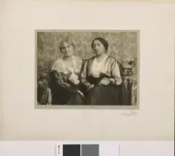 Portrett av to kvinner som sitter sammen. Kvinnen til venstr