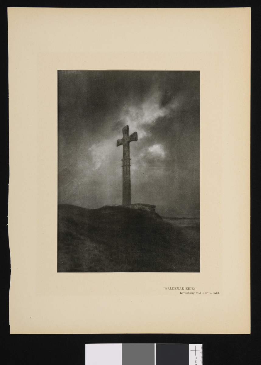 Et kors på en haug som rager mot himmelen.