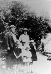 En mann og en kvinne, begge med hatt, og fire må jenter i kj