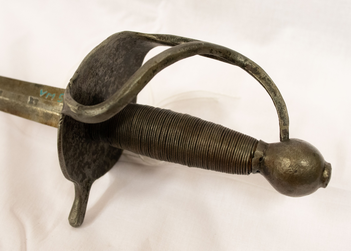 Värja, kommisvärja (ursprungligen modell 1685). 1832 ändrad till huggare för flottan. Kavelns lindning av svärtad järntråd. 