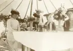 Fem kvinnor och en liten pojke (?) har samlats vid ett uppdukat matbord i ett stort tält.
1:a kvinnan t, v.: fru Elisabeth Bergstedt.