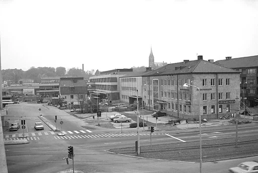 Fotografi som är taget från den då nya gjutna motorbron Mölndals bro.


Bredvid skylten där det står Domus på, så finns en vit banderoll uppsatt där det står "öppnar här 11/11". Eftersom Mölndalsbro invigs 1976-11-11, så borde fotografiet vara taget tidigare under år 1976.

I bakgrunden skymtar Fässbergs kyrktorn och tittar man nog så ser man även en fabriksskorsten skymta i bakgrunden.

Till höger i bild ses Hantverkshuset med skyltningen för Götabanken och längst fram i bild ses spårvagnsspåren. Längst till vänster syns en Volvo Amazon, som väntar på sin tur att få köra vid ett av trafikljusen.