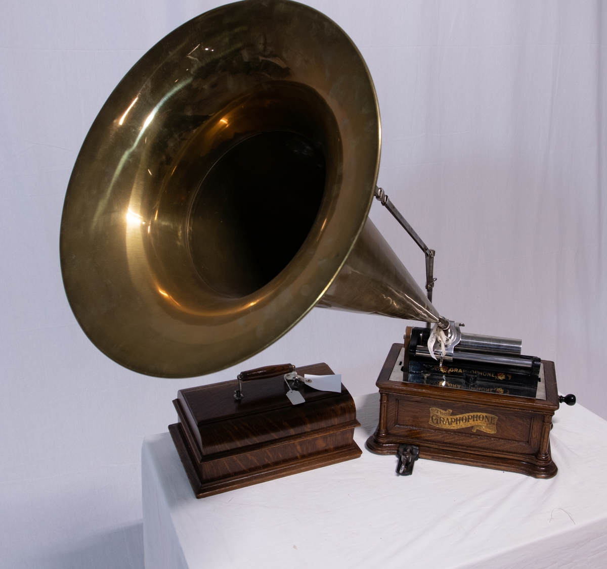 Sveivefonograf. Comlumbia Graphophone modell BF, også kalt "Peerless", nr. 7644. Fonografen er laget for av- og innspilling av 2- og 3 minutters sylindere. Avspillingslydhodet er en "Lyric" nr. 55735. Innspillingslydhodet er uten nr. og navn. Motoren er sveivetrukket med 4 fjærer.

Kassen er i brun eik med buet avtagbart lokk. Kassen er dekorert med utskjærte søyler i hjørnen. På baksiden av kassen er det montert et opphengsstativ til et stort messinghorn.