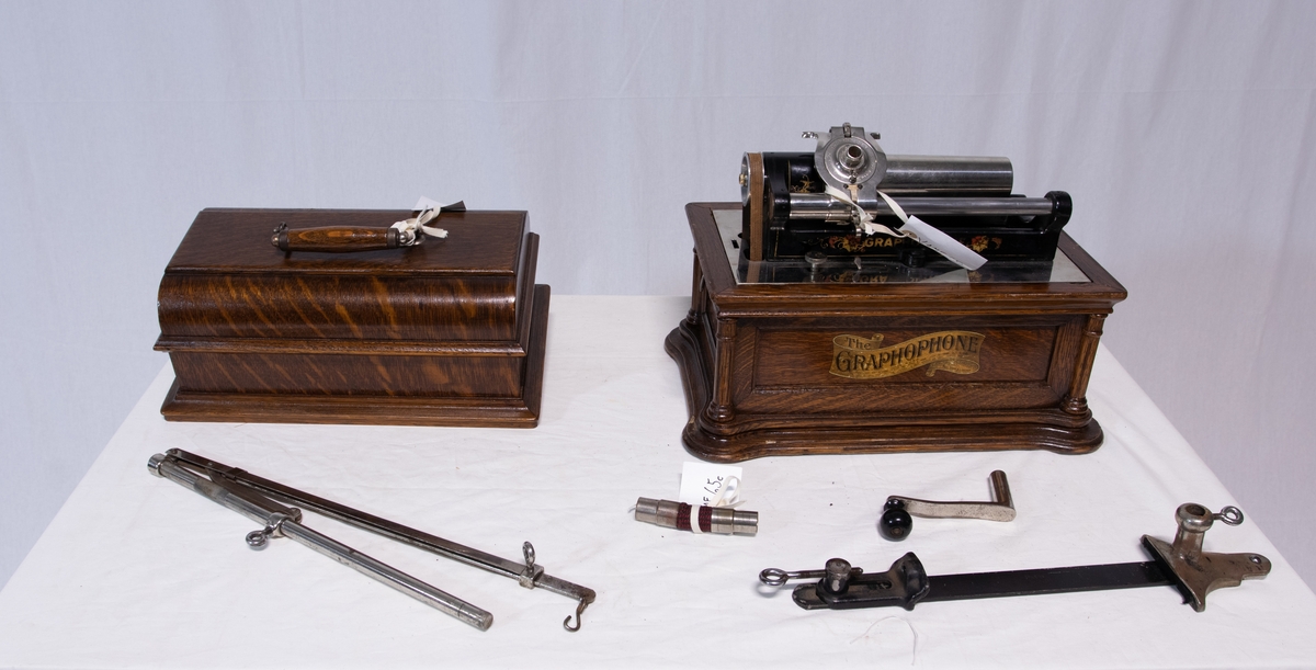 Sveivefonograf. Comlumbia Graphophone modell BF, også kalt "Peerless", nr. 7644. Fonografen er laget for av- og innspilling av 2- og 3 minutters sylindere. Avspillingslydhodet er en "Lyric" nr. 55735. Innspillingslydhodet er uten nr. og navn. Motoren er sveivetrukket med 4 fjærer.

Kassen er i brun eik med buet avtagbart lokk. Kassen er dekorert med utskjærte søyler i hjørnen. På baksiden av kassen er det montert et opphengsstativ til et stort messinghorn.