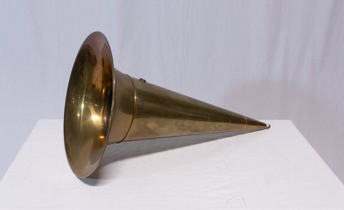 Sveivefonograf. Comlumbia Graphophone modell BF, også kalt "Peerless", nr. 7644. Fonografen er laget for av- og innspilling av 2- og 3 minutters sylindere. Avspillingslydhodet er en "Lyric" nr. 55735. Innspillingslydhodet er uten nr. og navn. Motoren er sveivetrukket med 4 fjærer.

Kassen er i brun eik med buet avtagbart lokk. Kassen er dekorert med utskjærte søyler i hjørnen. På baksiden av kassen er det montert et opphengsstativ til et stort messinghorn.