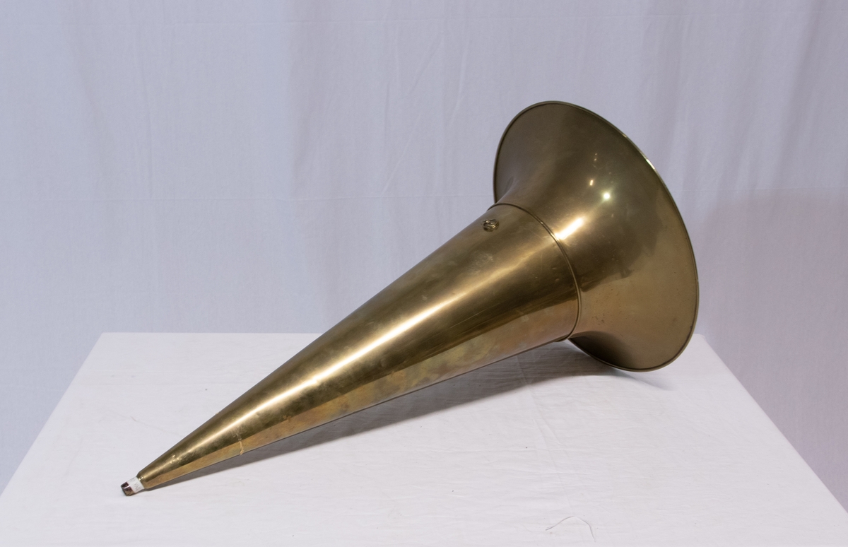 Sveivefonograf. Comlumbia Graphophone modell BF, også kalt "Peerless", nr. 7644. Fonografen er laget for av- og innspilling av 2- og 3 minutters sylindere. Avspillingslydhodet er en "Lyric" nr. 55735. Innspillingslydhodet er uten nr. og navn. Motoren er sveivetrukket med 4 fjærer.

Kassen er i brun eik med buet avtagbart lokk. Kassen er dekorert med utskjærte søyler i hjørnen. På baksiden av kassen er det montert et opphengsstativ til et stort messinghorn.