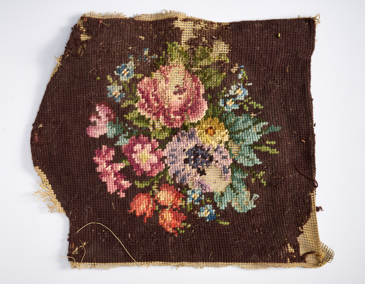 Ulike strikkete stoffrester i ulike farger og mønster. Et stoff er et brodert stoltrekk med blomstermønster. Funnet i en kasse tilhørende Hans Nissengården.