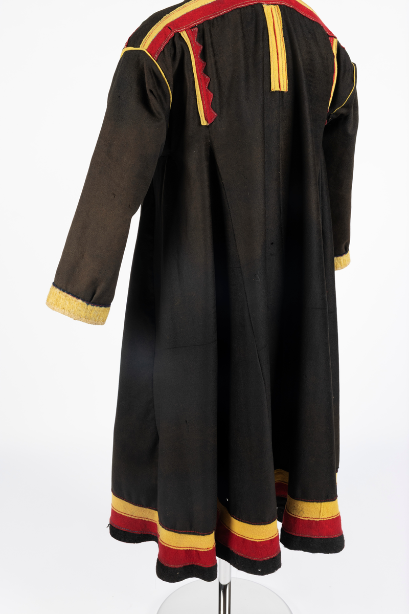 Svart kofte av klede med dekor av gult, rødt og beige klede.