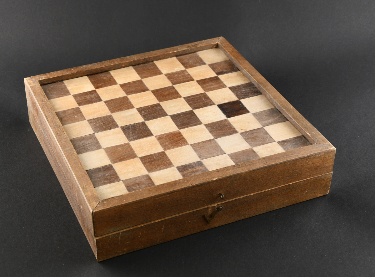 Brettspill med dam, backgammon og mølle. Firkantet eske av tre med hengslet lokk og krok for feste.