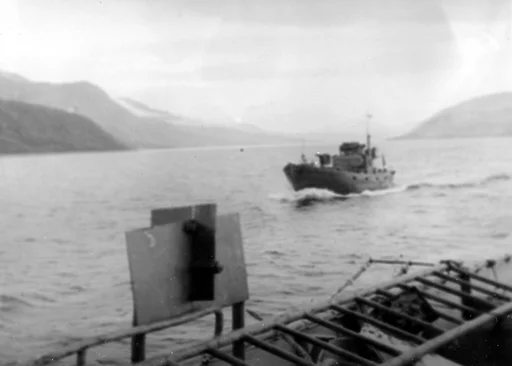 En tysk krigsfiskekutter (KFK) i tjeneste ved en havnevernflotilje i Nord-Norge. Fotografert fra en tysk motorminesveiper ved 7. motorminesveiperflotilje (7. R-Fl).