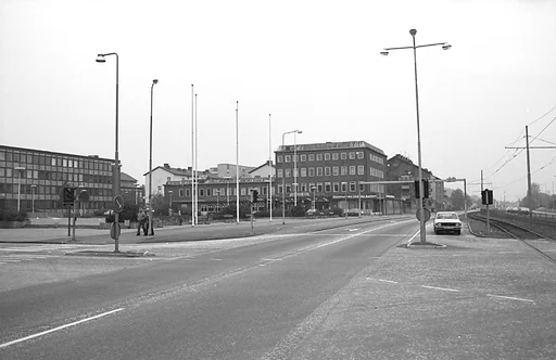 Fotografiet är taget någon gång i början av 1970-talet.

I bakgrunden ser vi stadshuset och Mölndals stadsbibliotek/Folkets hus/Kulturhuset Möllan. På bottenvåningen ser vi en lång skylt, med texten SKANDINAVISKA ENSKILDA BANKEN.

Vi ser hur biltrafiken kör förbi in till Göteborg och Mölndalsbro.
Fotgängare går över evergångsstället till vänster i bild.